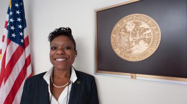 Woman posing by plaque