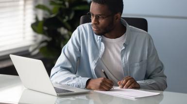 Man looking at white laptop
