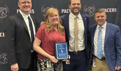 Picture of CEC's 2026 Teacher of the Year holding an award with her principal, superintendent, and CEC ED Chad Rummel