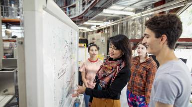 adult female teacher with group of high school students