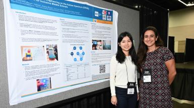 2 female students posing next to poster at annual CEC Convention
