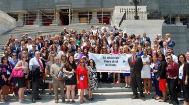 Lots of people holding a sign on the steps